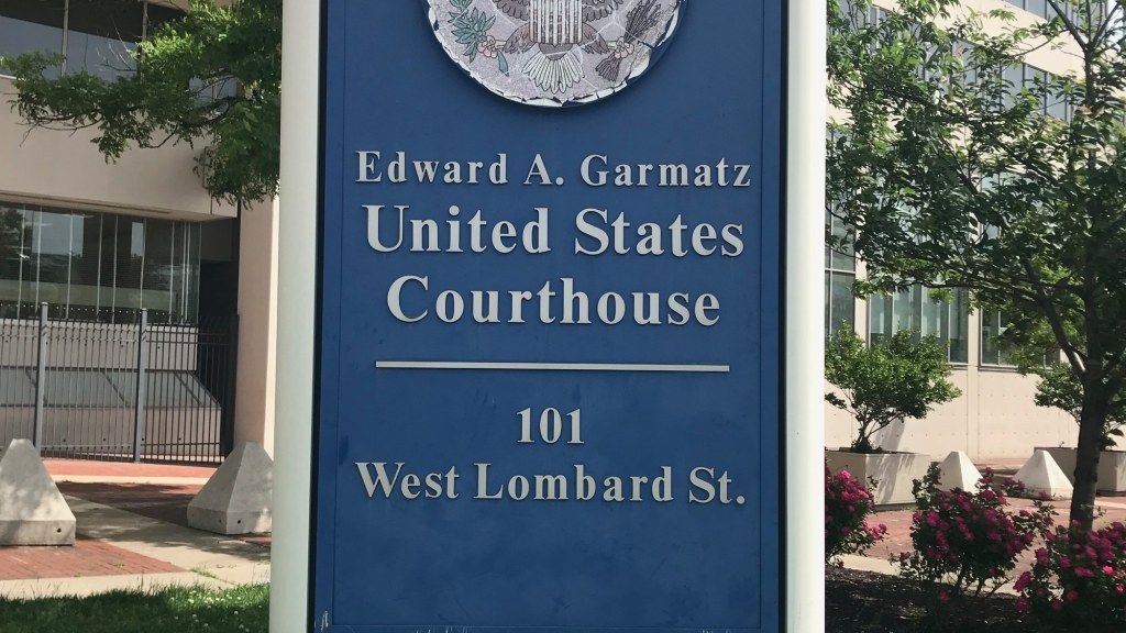 A blue sign reading Edward A. Garmatz United States Courthouse, 101 West Lombard St.
