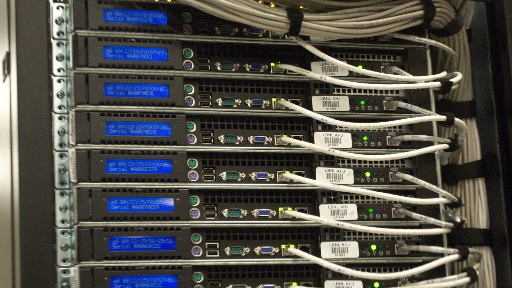 Close-up of network and power cables running along the back of a data center server rack.
