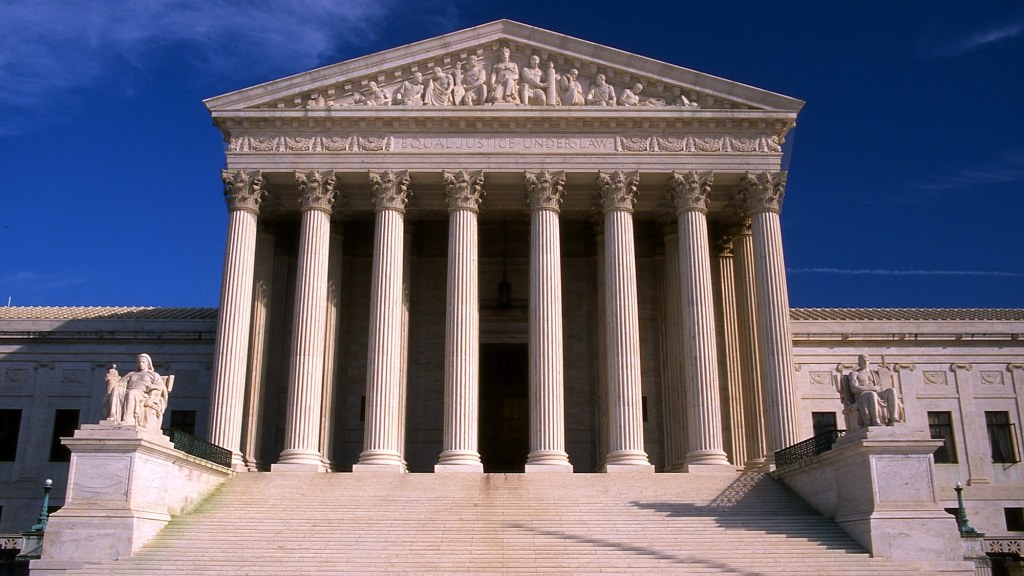 The white marble west facade of the U.S. Supreme Court building with its columns and steps.