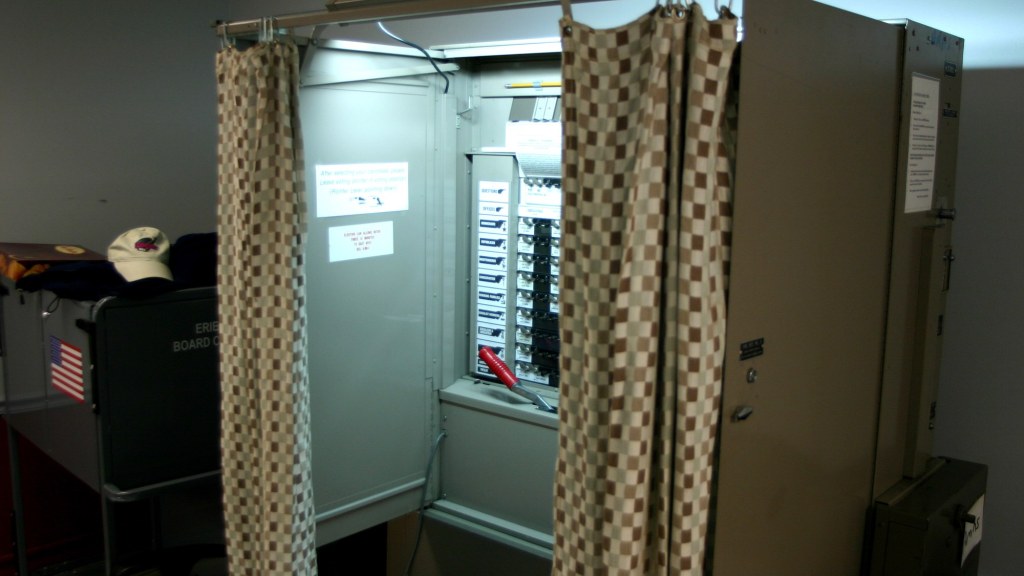 A curtained voting booth set up in a campus building.