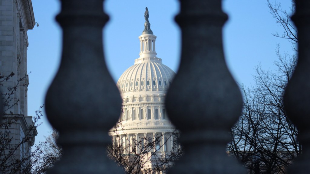 The white dome of the U.S. Capitol against a blue sky.